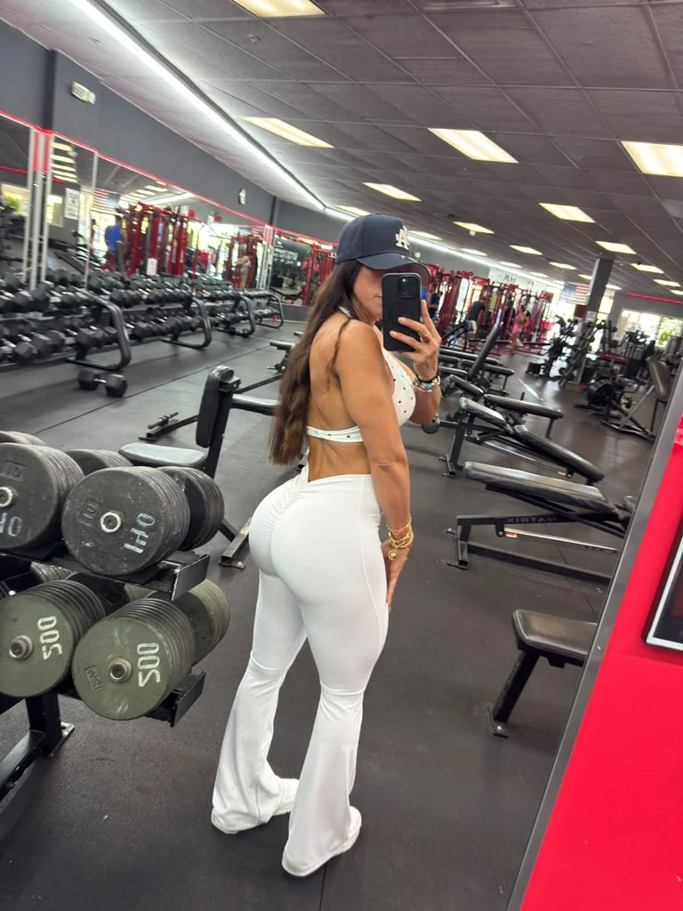 Keylimar Arguello con conjunto blanco junto a las pesas